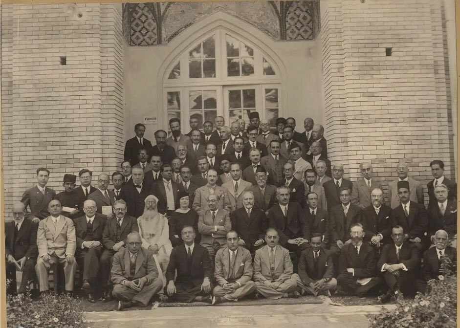 اعضای ایرانی و خارجی شرکتکننده در "کنگره بزرگداشت هزارمین سال تولد فردوسی" در جلوی درب تالار جنوبی مدرسه دارالفنون (1313ش)