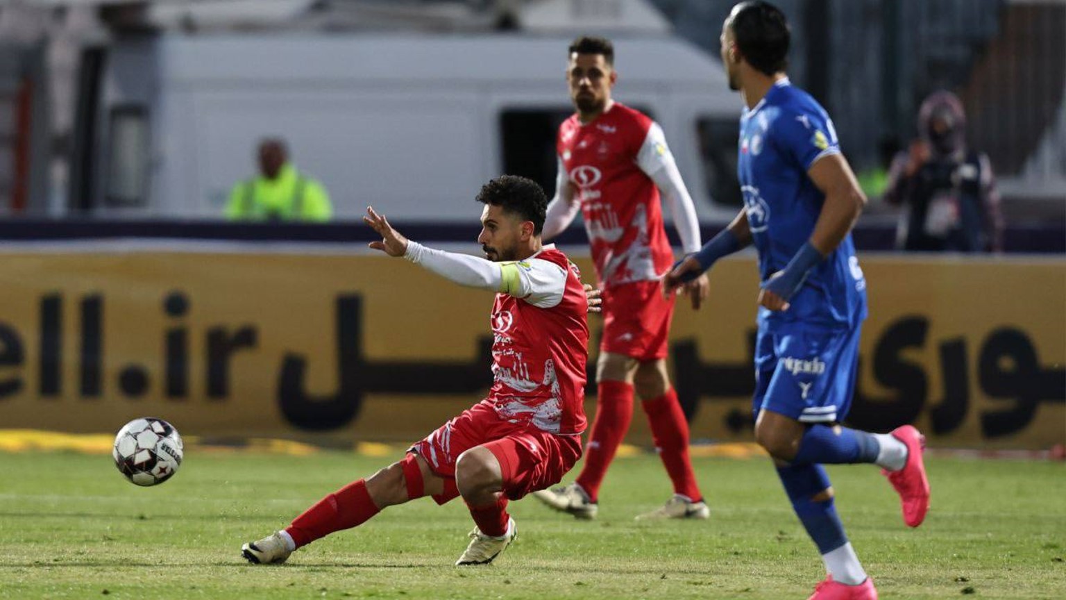 امید عالیشاه در حال سانتر کردن در بازی پرسپولیس و استقلال در کنار رامین رضاییان